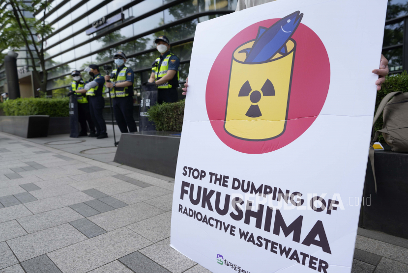  Seorang anggota kelompok sipil memegang spanduk menuntut penarikan keputusan pemerintah Jepang untuk melepaskan air radioaktif yang diolah dari pembangkit listrik tenaga nuklir Fukushima Daiichi yang rusak akibat gempa dan tsunami 2011, di dekat sebuah gedung yang menampung Kedutaan Besar Jepang di Seoul, Korea Selatan, Rabu, 2 Juni 2021.