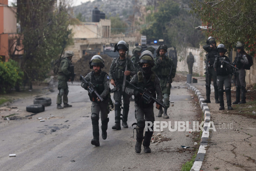  Tentara Israel dikerahkan selama bentrokan dengan warga Palestina di desa Burqa dekat kota Nablus, Tepi Barat, 23 Desember 2021. Bentrokan meletus setelah pemukim Israel tiba untuk memprotes di dekat desa tempat seorang pemukim dibunuh pekan lalu oleh warga Palestina.