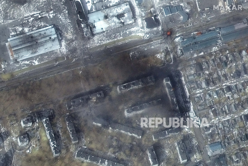 Citra satelit multispektral yang disediakan oleh Maxar Technologies menunjukkan tampilan dekat gedung apartemen dan kebakaran dengan kerusakan di area distrik Zhovtnevyi di Mariupol barat, Ukraina, selama invasi Rusia, Sabtu, 12 Maret , 2022.
