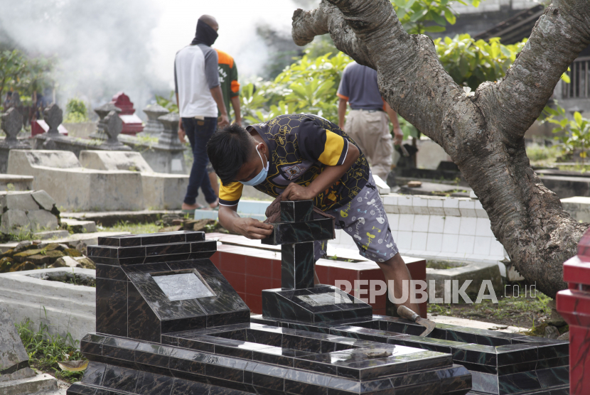 Warga memperbaiki makam saat kerja bakti di TPU Cemoro Kembar, Kelurahan Mojo, Pasarkliwon, Solo, Jawa Tengah, Rabu (23/6/2021). Kerja bakti tersebut dilakukan warga untuk memperbaiki  12 makam yang dirusak oleh 10 anak didik sebuah rumah belajar di daerah setempat. 