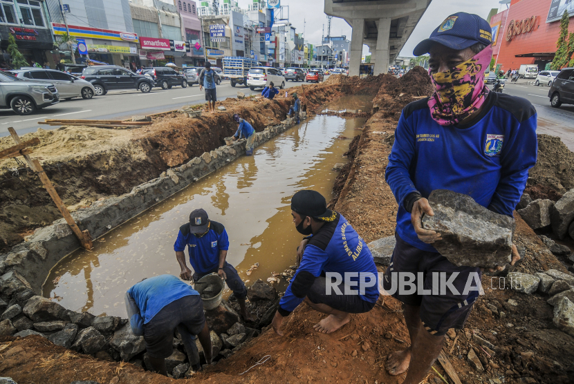 Petugas Dinas Sumber Daya Air menyelesaikan pembuatan kolam olakan di Jalan Boulevard Raya, Kelapa Gading, Jakarta, Kamis (28/1). Pemerintah Provinsi DKI Jakarta membuat kolam olakan yang dapat mengaliri air menuju saluran drainase kemudian dialirkan ke saluran penghubung sebagai salah satu upaya untuk mengatasi banjir yang kerap mleanda kawasan Kelapa Gading. Republika/Putra M. AKbar