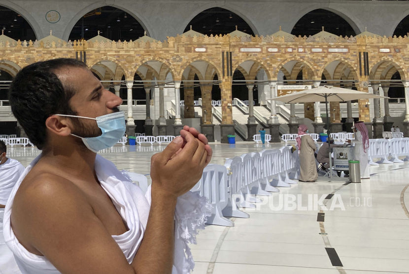 Pejabat Arab Saudi Siap Menerima Jamaah Haji. Seorang jamaah Muslim mengenakan masker untuk membantu menghentikan penyebaran virus corona saat dia berdoa di Masjidil Haram di kota suci Muslim Mekah, Arab Saudi, Minggu, 30 Mei 2021.