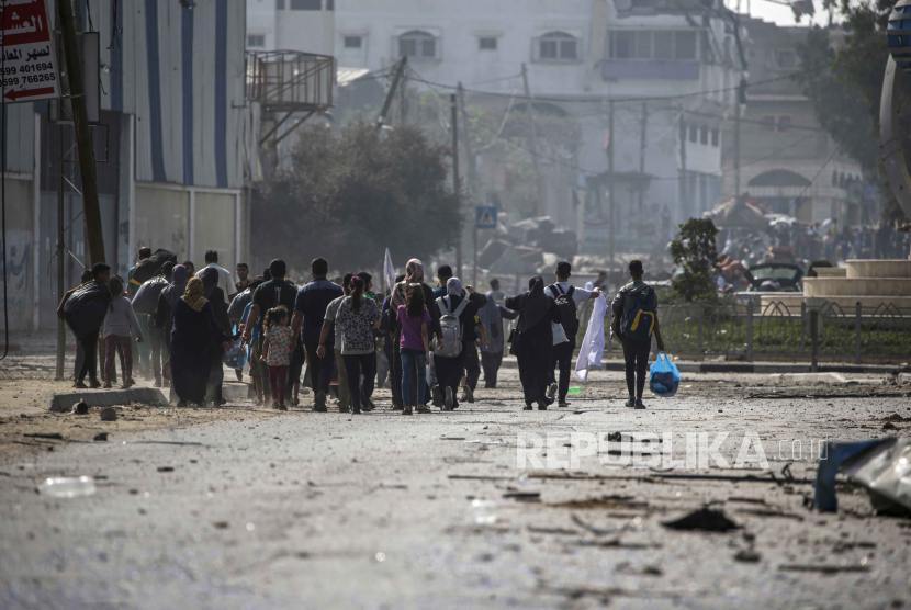 Warga berjalan kaki saat melakukan evakuasi di Jalur Gaza Utara, Ahad (5/11/2023).