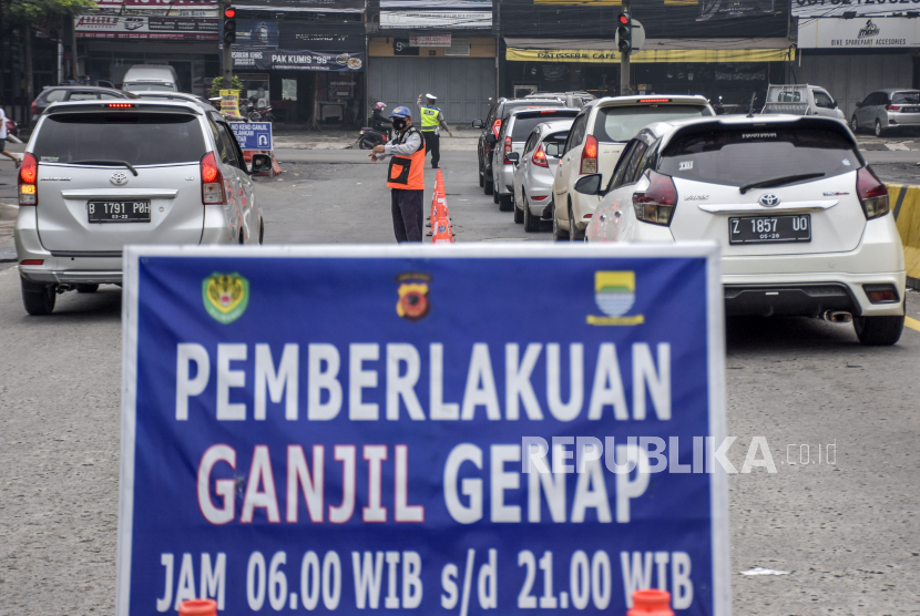 Petugas gabungan mengatur lalu lintas saat pemberlakuan ganjil genap di gerbang Tol Buah Batu, Kota Bandung.