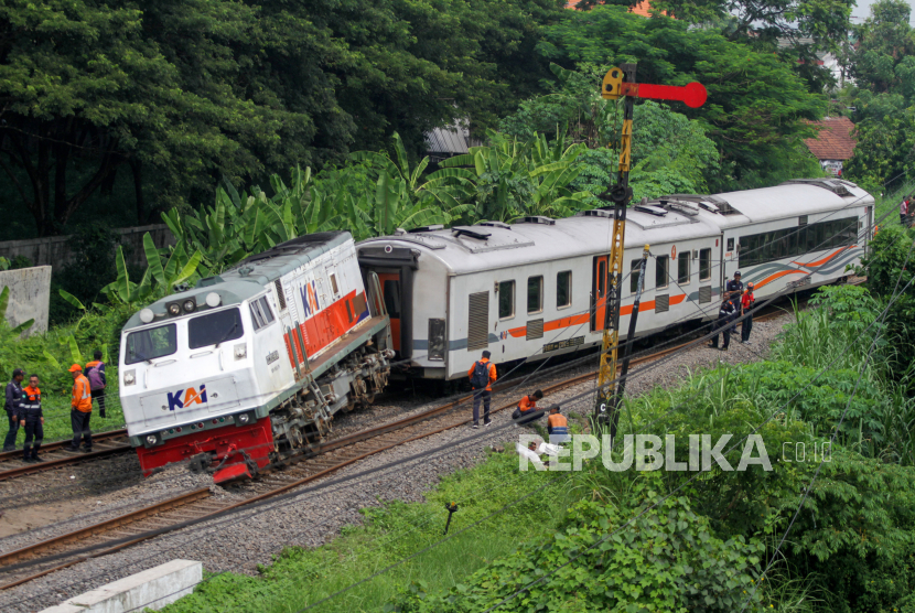 Petugas berada di samping kereta api yang anjlok di emplasemen Stasiun Tanggulangin, Sidoarjo, Jawa Timur, Ahad (14/1/2024). Anjloknya KA Pandalungan relasi Gambir-Surabaya-Jember tersebut belum diketahui penyebabnya. 