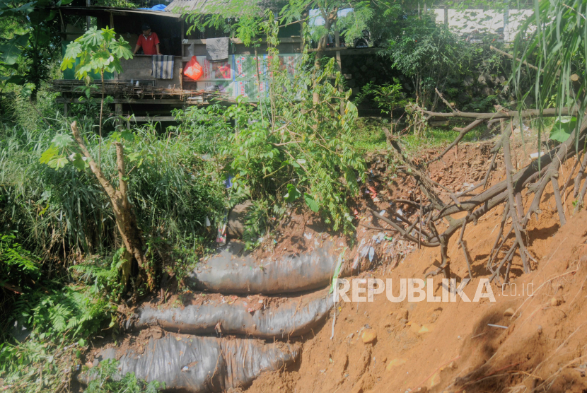 Seorang warga melihat kondisi tanah longsor di Jalan Babakan Fakultas, Tegallega, Kota Bogor, Jawa Barat. Sebanyak 10 titik bencana terjadi di Kota Bogor dalam sehari, longsor paling banyak.