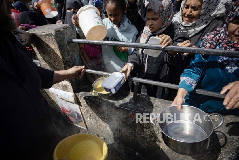 Pengungsi Palestina memegang mangkuk kosong saat berbaris untuk menerima bantuan makanan yang diberikan oleh kelompok pemuda Palestina di kamp pengungsi Rafah, Jalur Gaza selatan, (7/3/2024).