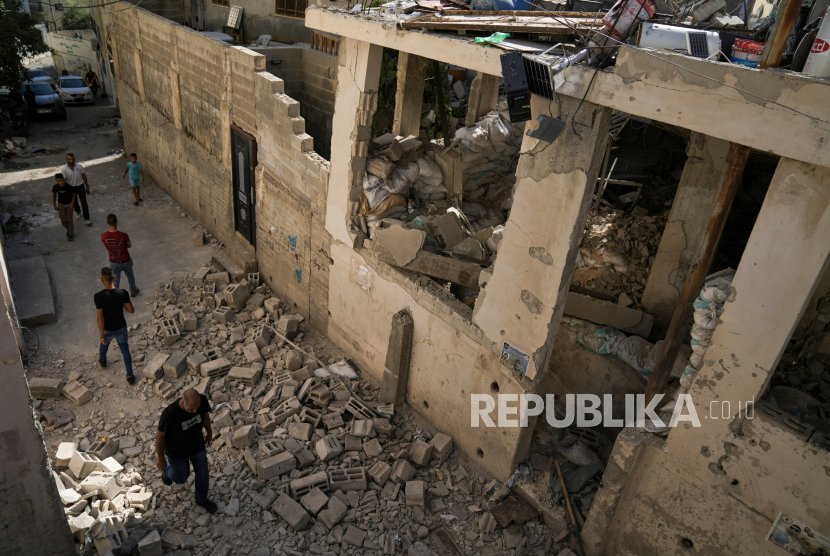 File - Warga Palestina berjalan melewati rumah yang rusak di kamp pengungsi Jenin di Tepi Barat,  pada 5 Juli 2023.