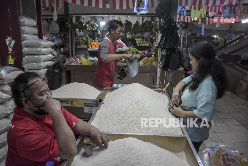 Pedagang beras melayani pembeli di kiosnya di Pasar Atas Cimahi, Kota Cimahi, Jawa Barat, Jumat (8/9/2023). 