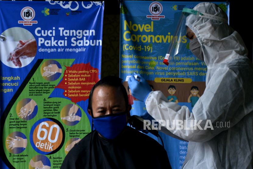 Mahasiswa Fakultas Teknologi Industri Universitas Muslim Indonesia (FTI UMI)  Makassar memangkas rambut seorang dokter sambil menggunakan Alat Pelindung Diri (APD) di Makassar, Sulawesi Selatan, Ahad (17/5/2020). Kegiatan itu diberikan kepada sejumlah dokter yang telah bertugas menangani pasien yang terjangkit virus COVID-19 selama dua bulan di rumah sakit