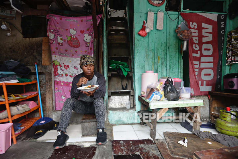 Pria makan di depan rumahnya di kawasan kumuh (Foto: ilustrasi).
