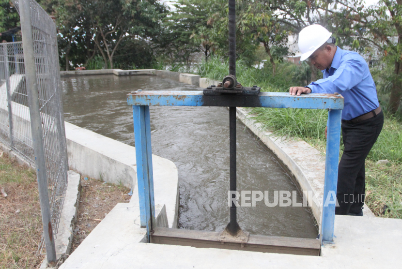 Seorang teknisi melakukan pemeliharaan rutin di kolam penampung air sungai yang merupakan rangkaian instalasi Pembangkit Listrik Tenaga Mikro Hidro di kampus UMM, Jawa Timur, Selasa (2/8/2022).