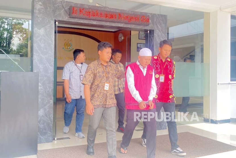 Petugas menggiring NS, kepala Desa Cigadog, Kecamatan Sucinaraja, Kabupaten Garut, yang menjadi tersangka kasus dugaan korupsi dana desa, Jumat (25/11/2023).