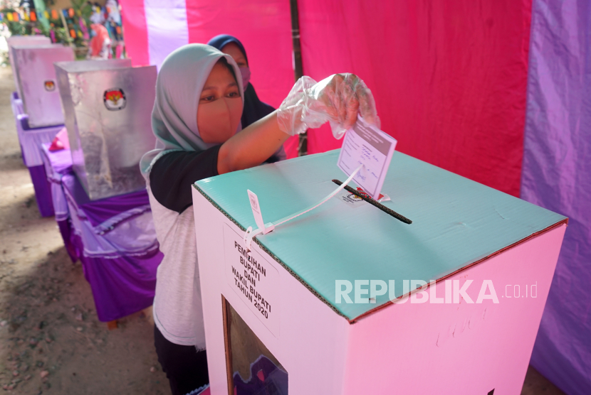 Seorang warga memasukkan surat suara ke dalam kotak suara usai mencoblos pada pemungutan suara Pilkada Kabupaten Gorontalo di TPS 2 Tinelo, Kabupaten Gorontalo, Gorontalo, Rabu (9/12/2020). Pilkada Kabupaten Gorontalo yang diikuti oleh empat pasang calon tersebut dilakukan dengan menerapkan protokol kesehatan pencegahan COVID-19. 