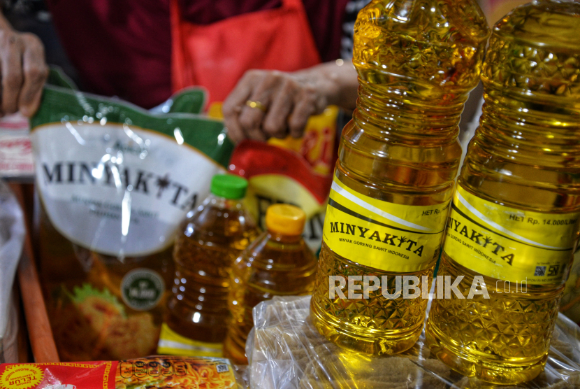 Pedagang menunjukan Minyakita di sebuah warung klontong di Jakarta, Senin (22/7/2024). 