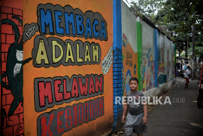 Warga beraktivitas di Kampung Literasi, Jalan Pal Meriam, Jakarta Timur, Senin (30/1/2023). 