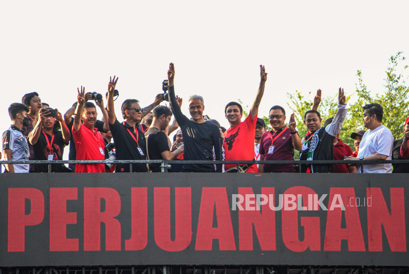 Calon presiden nomor urut tiga Ganjar Pranowo (tengah) menyampa peserta Jalan Sehat Perjuangan di Makassar, Sulawesi Selatan, Minggu (26/11/2023). Jalan sehat yang diikuti kader partai pengusung, relawan, dan simpatisan tersebut dirangkaikan dengan aksi kepedulian kemanusiaan kepada Palestina.  