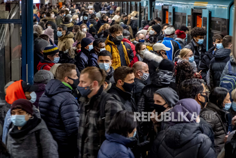  Orang-orang memakai masker wajah tetapi berdiri berdekatan saat menunggu kereta bawah tanah di Frankfurt, Jerman, Rabu, 2 Desember 2020.