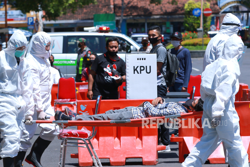 Petugas kesehatan mengangkat pemilih yang pingsan saat simulasi Pemilihan Kepala Daerah di Banyuwangi, Jawa Timur, Senin (14/9/2020). (ilustrasi)