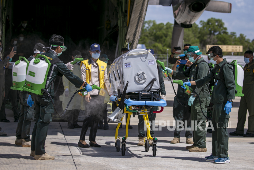 Tim medis menurunkan pasien positif terjangkit COVID-19 dari pesawat Hercules C-130 dan disemprot dengan desinfektan saat simulasi pemindahan pasien COVID-19 di Bandara Hang Nadim, Batam, Kepulauan Riau, Kamis (26/3/2020). Simulasi tersebut untuk melihat kesiapan personel medis dalam menangani proses pemindahan pasien khusus Corona (COVID-19) dari  pesawat untuk dibawa ke RS Khusus Corona di Pulau Galang, Batam