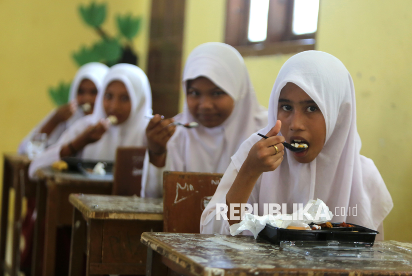 Sejumlah murid menyantap makanan pada program Makan bergizi Gratis bantuan Ikatan Wanita Pengusaha Indonesia (IWAPI) Provinsi Aceh di SDN Monsinget, daerah pesisir Desa Kajhu, Aceh Besar, Aceh, Senin (10/2/2025). IWAPI bersama Pemkab Aceh Besar membagikan sebanyak 1.350 pack makanan dalam upaya turut menyukseskan program Makan Bergizi Gratis yang dicanangkan pemerintah. 