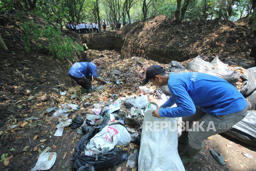 Petugas kebersihan memasukan sampah organik ke lubang yang baru di kawasan Tegallega, Kota Bandung. Sekda Kota Bandung memastikan TPST Gedebage akan beroperasi mulai pekan depan.