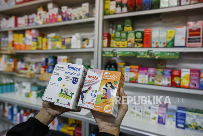 Seorang penjaga toko memperlihatkan beberapa obat sirop yang dijual di sebuah toko obat di Jakarta, 19 Oktober 2022. Kementerian Kesehatan Republik Indonesia mengeluarkan pengumuman yang meminta apotek dan petugas kesehatan untuk menghentikan sementara resep sirup dan obat cair menyusul kematian hampir 100 anak akibat cedera ginjal akut .
