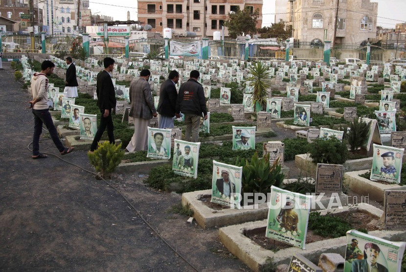  Warga Yaman mengunjungi makam kerabat yang terbunuh di pemakaman orang yang tewas dalam perang di Yaman, di Sanaa.