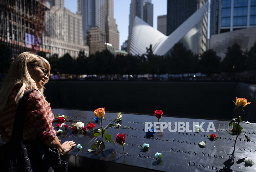  Pelayat berkumpul di kolam utara yang dihiasi dengan bunga selama upacara untuk memperingati 20 tahun serangan teroris 11 September 2001, Sabtu, 11 September 2021, di National September 11 Memorial & Museum di New York. Museum 11 September ditutup karena minimnya pengunjung.