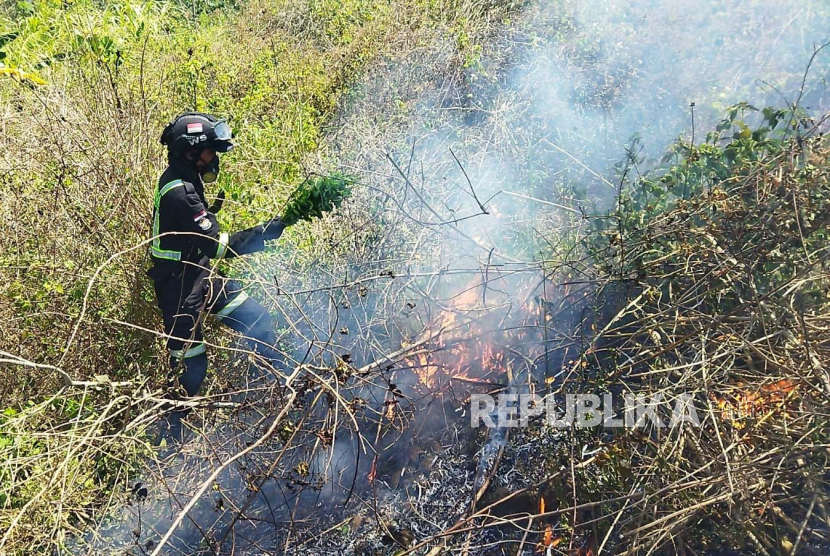 Petugas pemadam kebakaran (Damkar) berupaya memadamkan api di lahan titisara Desa Randobawagirang, Kecamatan Mandirancan, Kabupaten Kuningan, Jawa Barat, Senin (14/8/2023).