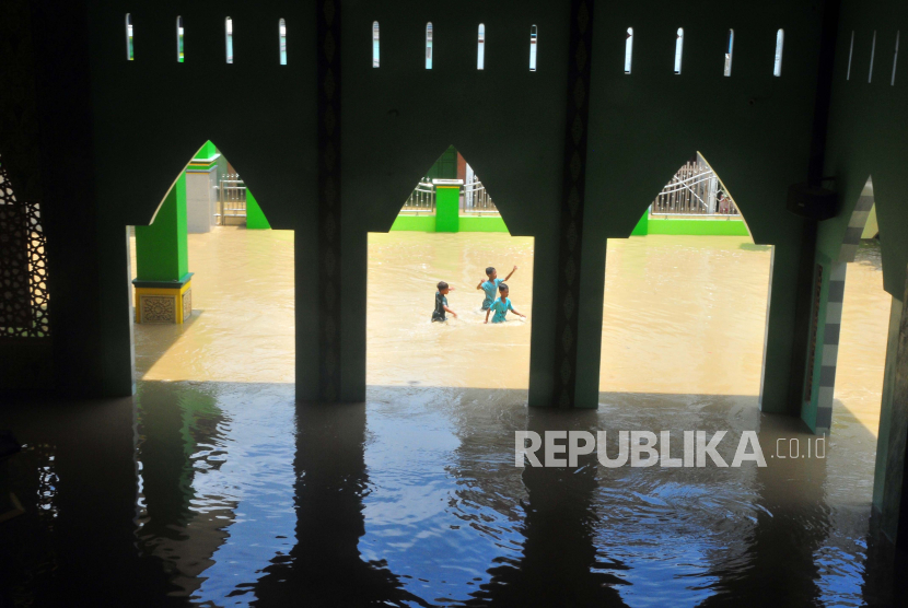 Sejumlah anak berjalan di halaman masjid yang tergenang banjir di Desa Gubug, Kecamatan Gubug, Kabupaten Grobogan, Jawa Tengah, Selasa (6/2/2024).