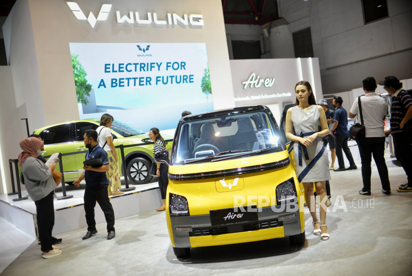 Pengunjung mengamati mobil listrik dalam pameran.