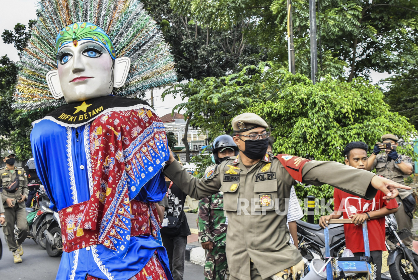 Sejumlah petugas gabungan dari TNI dan Satpol PP saat melakukan razia pengamen ondel-ondel di Jakarta Timur, Rabu (24/3/2021). Razia tersebut untuk menertibkan  Penyandang Masalah Kesejahteraan Sosial (PMKS) yang dinilai kerap menganggu ketertiban umum. 