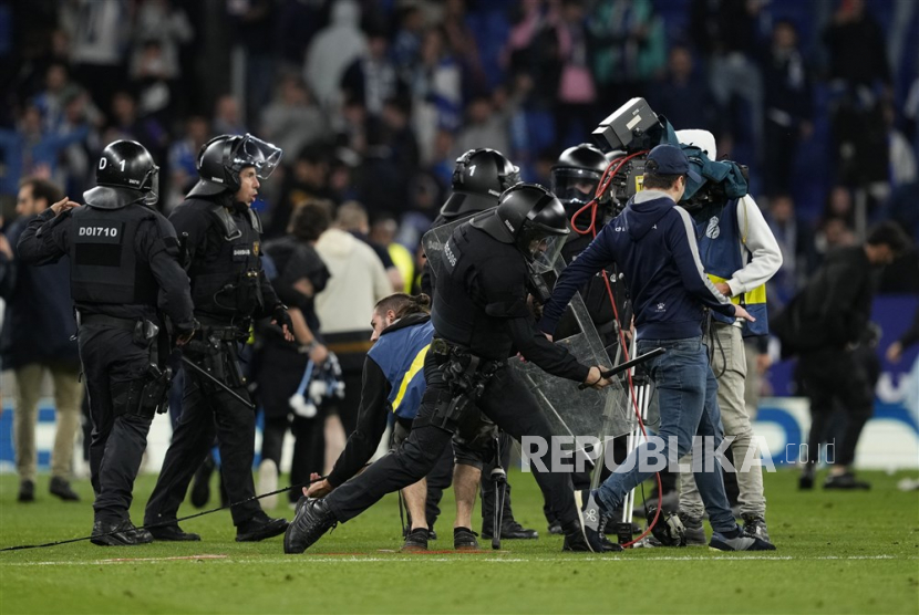 Petugas Polisi Nasional Spanyol berusaha menghentikan suporter Espanyol yang menyerbu lapangan setelah kalah dalam pertandingan sepak bola LaLiga Spanyol antara RCD Espanyol dan FC Barcelona, ??di Barcelona, ??Catalonia, Spanyol, Senin (15/5/2023) dini hari WIB.3.