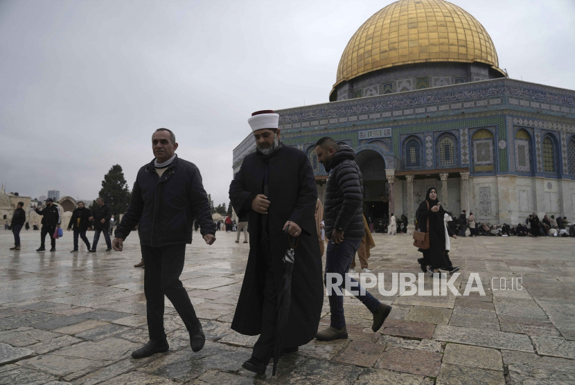  Seorang pria berjalan dari Masjid Dome of the Rock saat jamaah berkumpul untuk sholat Jumat di hari yang dingin dan hujan di kompleks Masjid Al-Aqsa di Kota Tua Yerusalem, Jumat (6/1/2023). Dewan Keamanan PBB Tekankan Status Quo Masjid Al Aqsa
