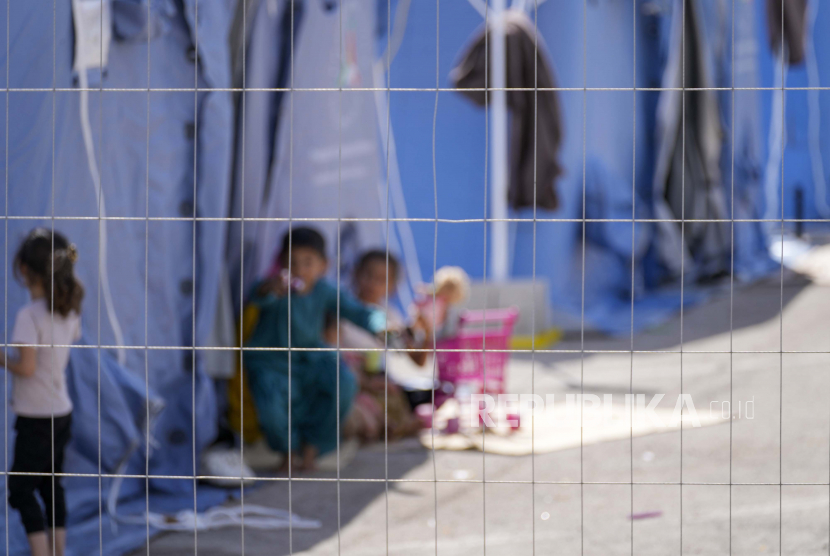  Anak-anak Afghanistan bermain dengan mainan di kamp pengungsi Palang Merah Italia, di Avezzano, Italia, Selasa, 31 Agustus 2021. Kamp karantina di Abruzzo, Italia tengah ini, tempat 1.250 migran ditampung, diperkirakan akan ditutup dalam seminggu karena karantina berakhir dan mereka dipindahkan ke struktur lain untuk mengajukan suaka.