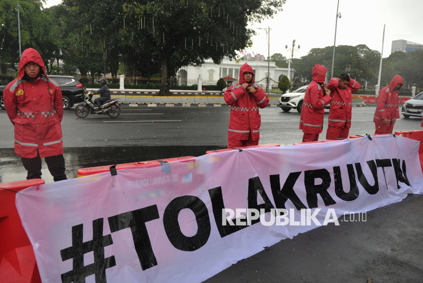 Personel kepolisian berjaga saat aktivis dari Jaringan Solidaritas Korban untuk Keadilan (JSKK) menggelar Aksi Kamisan ke-856 di seberang Istana Merdeka, Jakarta, Kamis (20/3/2025). Dalam aksinya mereka menolak  pengesahan Revisi Undang-Undang Tentara Nasional Indonesia (TNI) oleh DPR karena dinilai akan mengancam supremasi sipil, selain itu mereka juga menuntut pemerintah untuk menuntaskan kasus pelanggaran HAM dan mendesak pemerintah untuk membuat kebijakan yang melindungi hak-hak sipil.