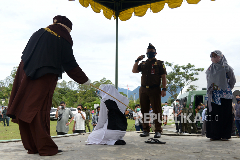 Algojo melakukan eksekusi hukuman cambuk terhadap salah seorang pasangan terpidana dalam kasus zina di Masjid Al Munawarah, Kota Jantho, Kabupaten Aceh Besar, Aceh, Jumat (4/9/2020). Pasangan terpidana yang terbukti melanggar Syariat Islam dalam kasus zina itu masing masing menjalani sebanyak 100 cambuk dengan tetap menerapkan protokol kesehatan guna mencegah penyebaran COVID-19.