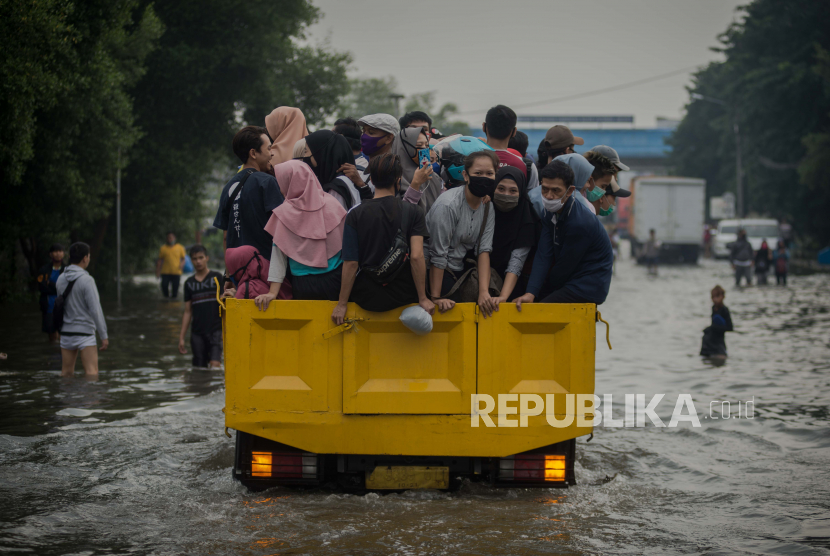 Pekerja menaiki truk untuk menerobos banjir rob di kawasan Pelabuhan Nizam Zachman, Jakarta Utara, Jumat (5/6). Banjir rob setinggi sekitar 20-60 centimeter tersebut terjadi akibat air laut pasang yang merendam kawasan pelabuhan dan pemukiman warga