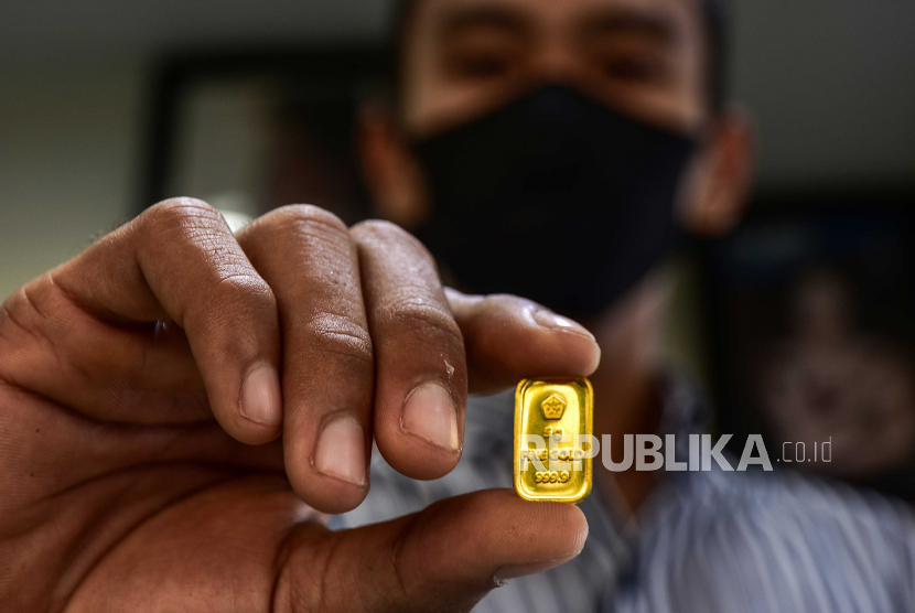 Seorang pegawai menunjukkan kepingan emas di toko dan perhiasan di Kota Pekanbaru, Riau. Harga emas Antam dirilis Rp 1.065.000 per gram pada perdagangan Jumat (7/8) ini.