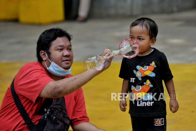 Anak dan orang tuanya bermain di kawasan Taman Puring, Jakarta, Ahad (2/1/2022). Stimulasi emosi anak perlu dilakukan dengan gestur yang konkret, seperti dengan bermain bersama anak.