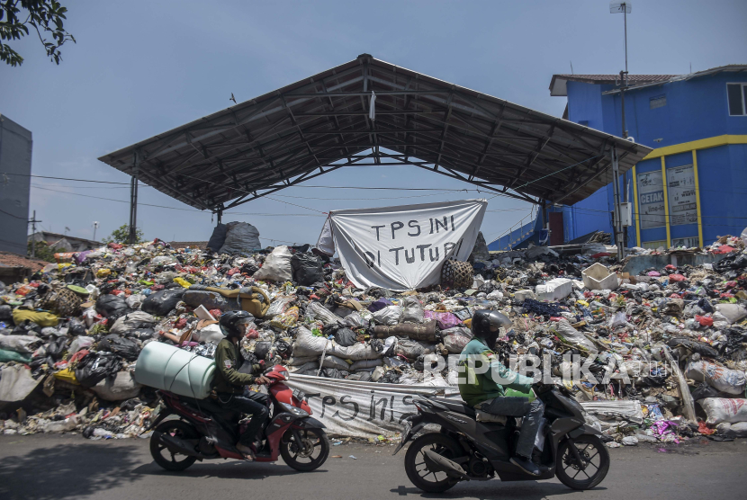 Pengendara melintas di samping tumpukan sampah di TPS Pagarsih, Kota Bandung, Jawa Barat, Jawa Barat, Kamis (26/10/2023). 