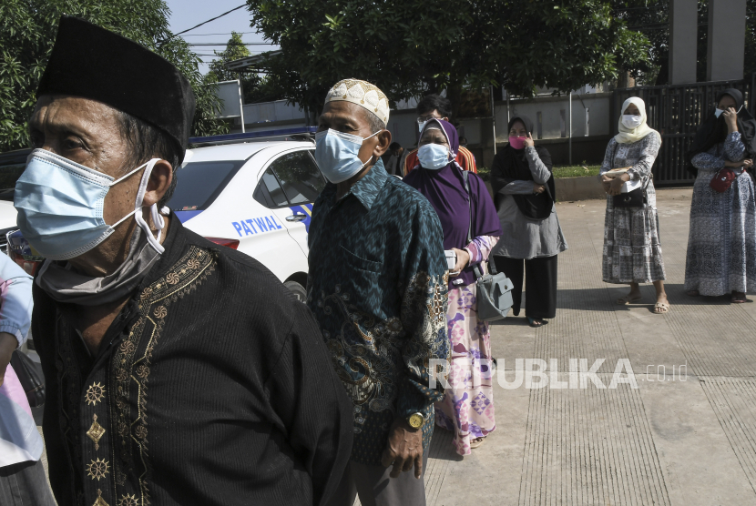 Sejumlah warga antre untuk mengambil BLT (Bantuan Langsung Tunai) dana desa di Setu, Kabupaten Bekasi, Jawa Barat, Rabu (28/7/2021). Kementerian Keuangan mencatat realisasi BLT Dana Desa baru 21,3% karena pemerintah daerah melakukan verifikasi ulang data penerima warga yang terdampak pandemi COVID-19. 