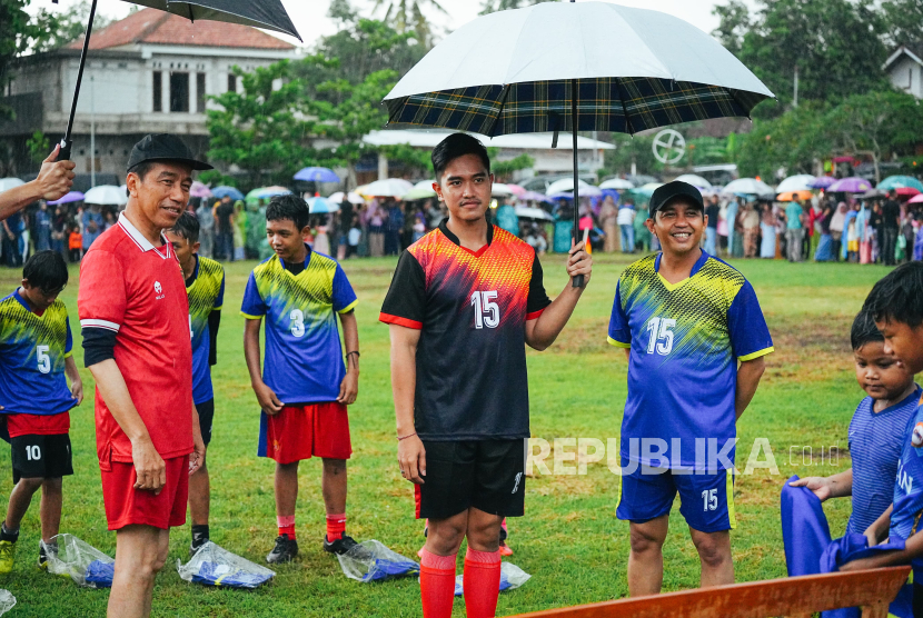 Presiden Joko Widodo (kiri) bersama Kaesang Pangarep (tengah) bermain bola dengan warga di Lapangan Gamplong, Sleman, Sabtu (27/1/2024).