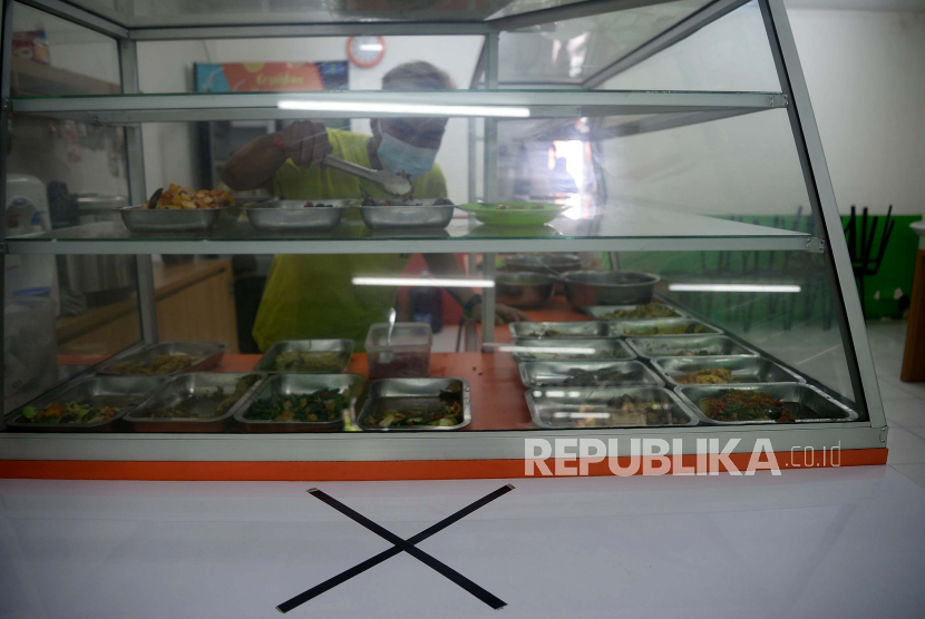 Penjual melayani pembeli di Rumah Makan Wartegan, Ampera, Jakarta Selatan, Senin (26/7). 