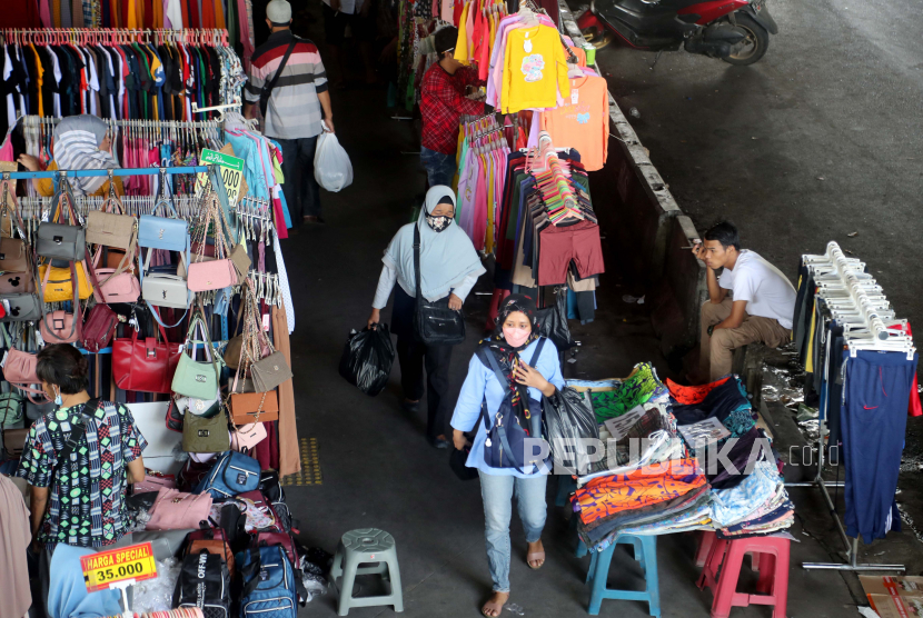  Orang berjalan di antara pedagang kaki lima di Jakarta, Selasa (16/11). Laju inflasi sepanjan November 2021 tercatat 0,37 persen atau yang tertinggi sejak awal tahun ini. 
