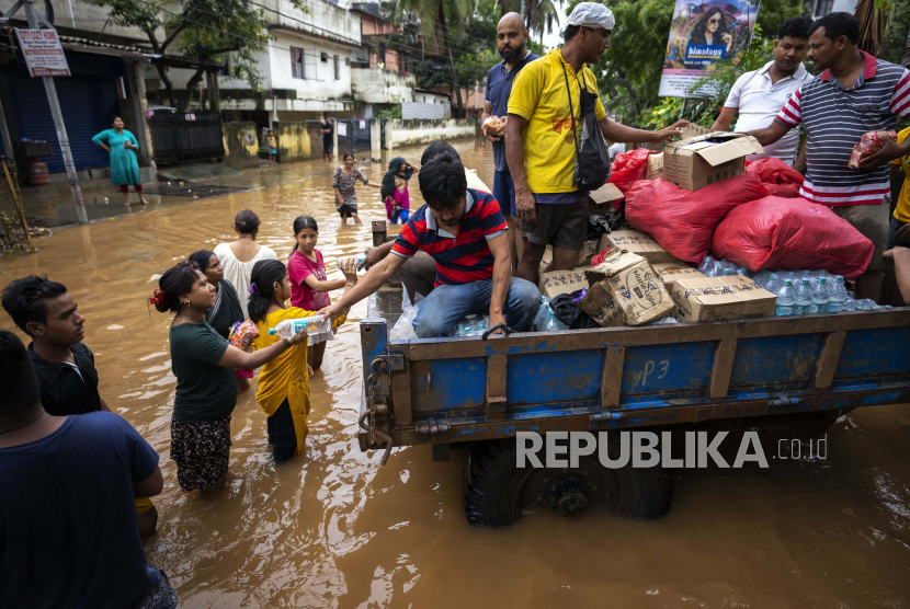  Pekerja kota membagikan makanan dan air kepada orang-orang yang terkena banjir. Badai musiman di Bangladesh dan India menyebabkan banjir yang menewaskan 41 orang. Ilustrasi.