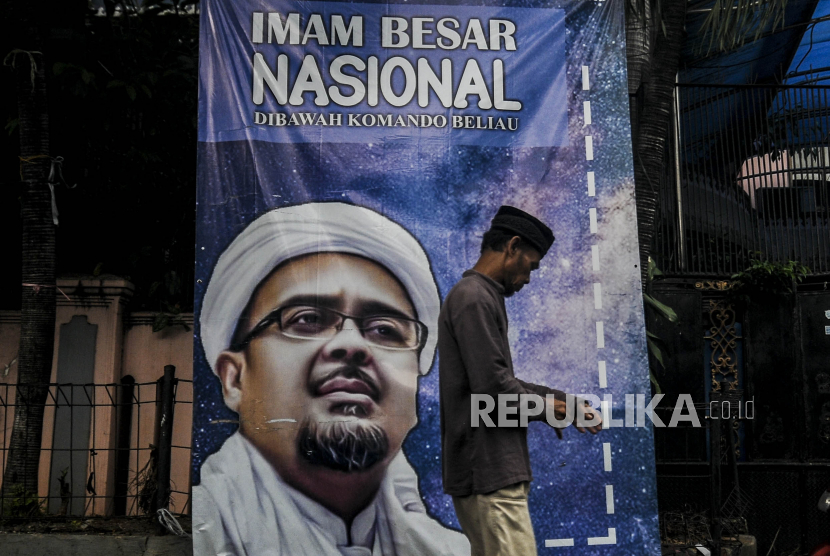 Seorang warga melintas di depan spanduk Imam Besar Front Pembela Islam (FPI) Habib Rizieq Shihab yang terpasang di kawasan Petamburan III, Jakarta, Rabu (30/12). Pemerintah resmi membubarkan dan menghentikan segala aktivitas FPI sebagai organisasi masyarakat maupun organisasi pada umumnya. Republika/Putra M. Akbar