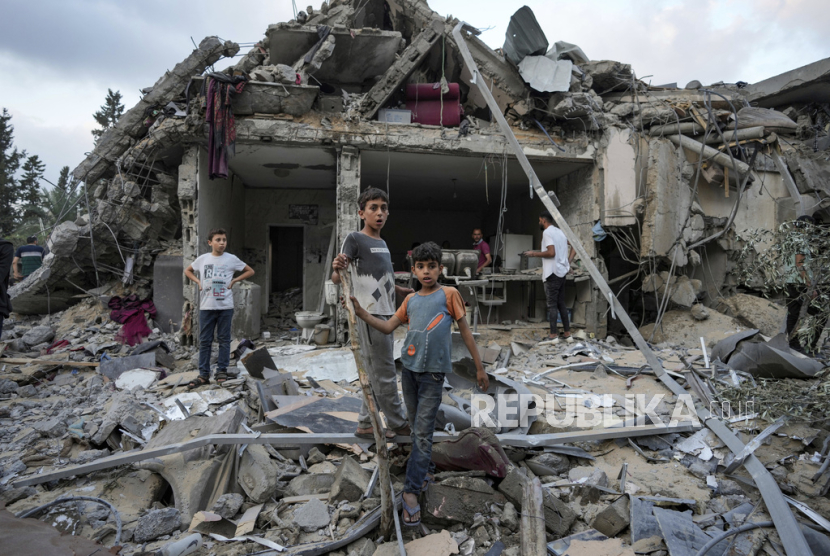 Palestinians look at the destruction after an Israeli airstrike in Deir al Balah, Gaza Strip, Tuesday, April 30, 2024. 