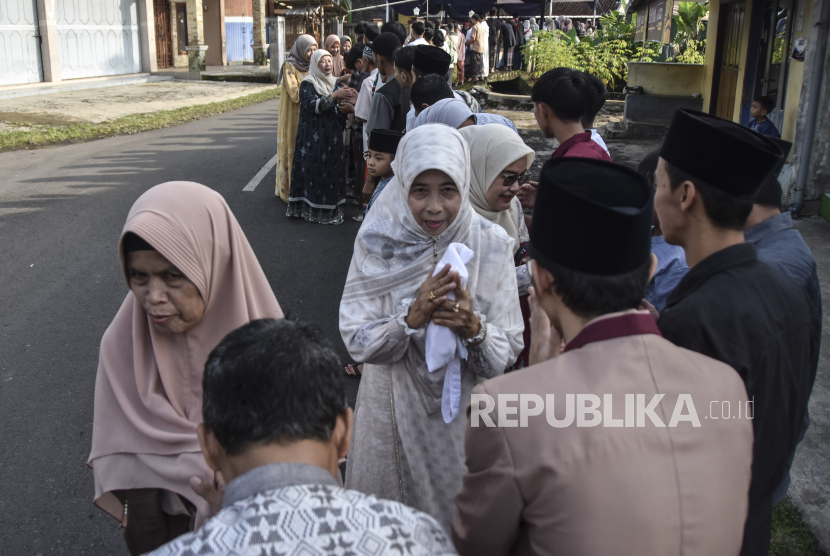 Sejumlah warga bersalaman usai melaksanakan shalat Idul Fitri di Desa Darmaraja, Ciamis, Jawa Barat, Rabu (10/4/2024). Tradisi bersalaman massal lebaran antardusun tersebut dilaksanakan pada perayaan Idul Fitri 1445 Hijriah untuk saling memaafkan dan menjaga tali silaturahim serta memperkokoh kerukunan antarumat beragama. 